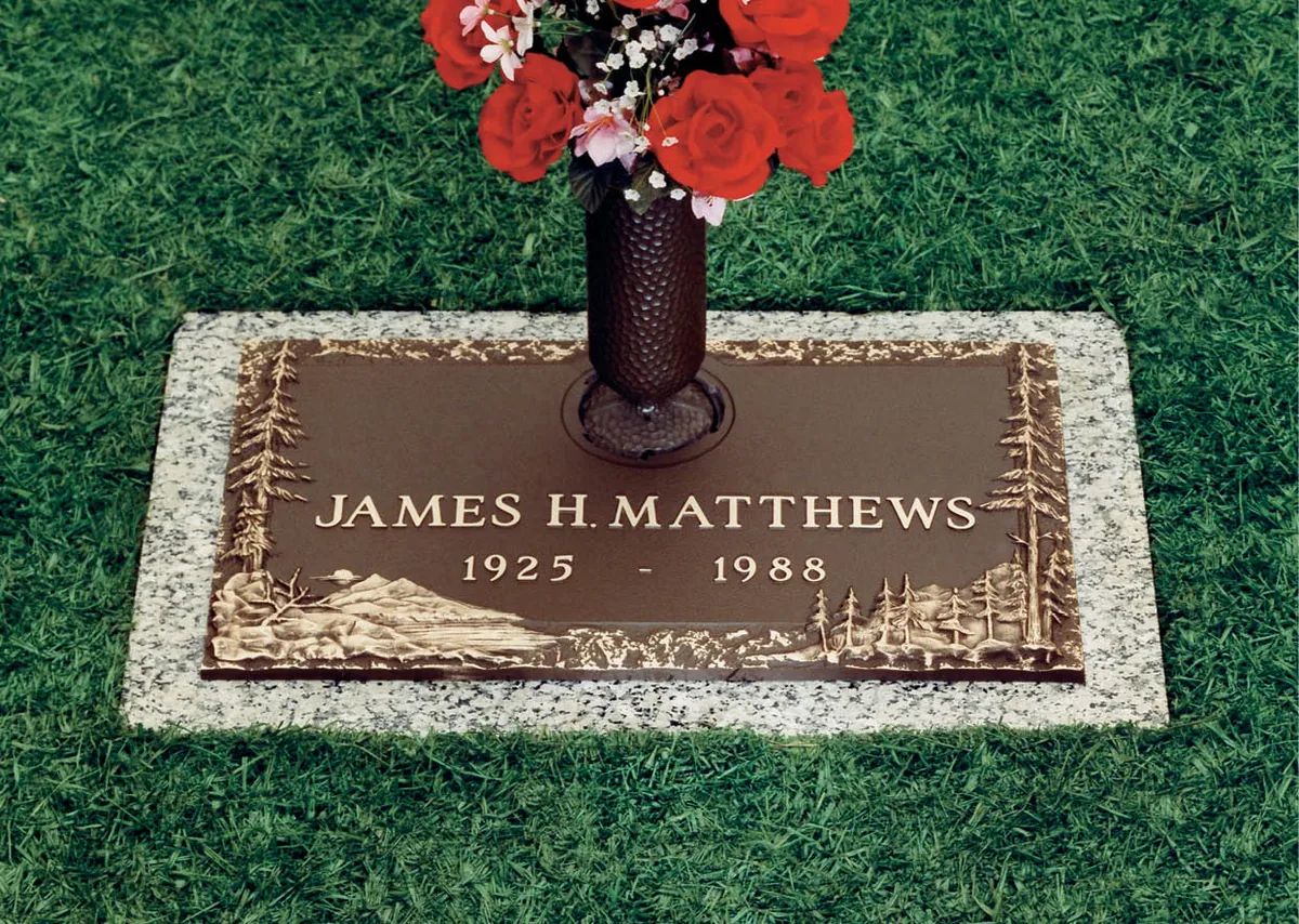 A bronze marker with a sculpted landscape scene cast into the face of the metal