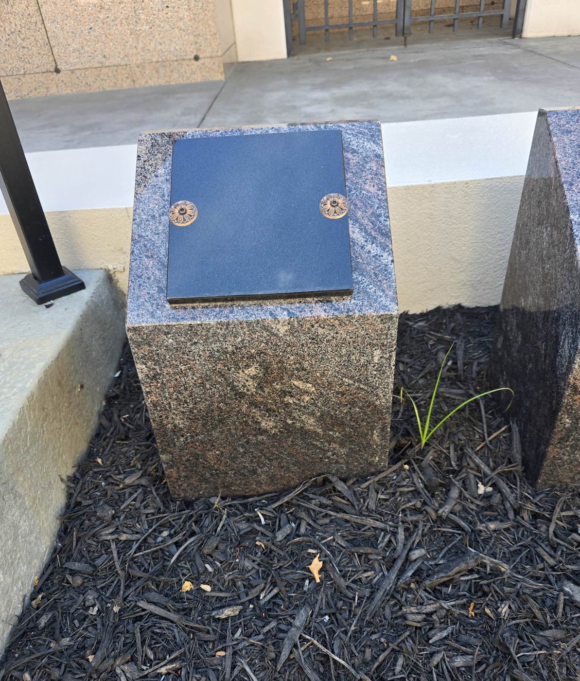 A granite cremation boulder with two bronze covers on the Terrace Garden Memorial Path