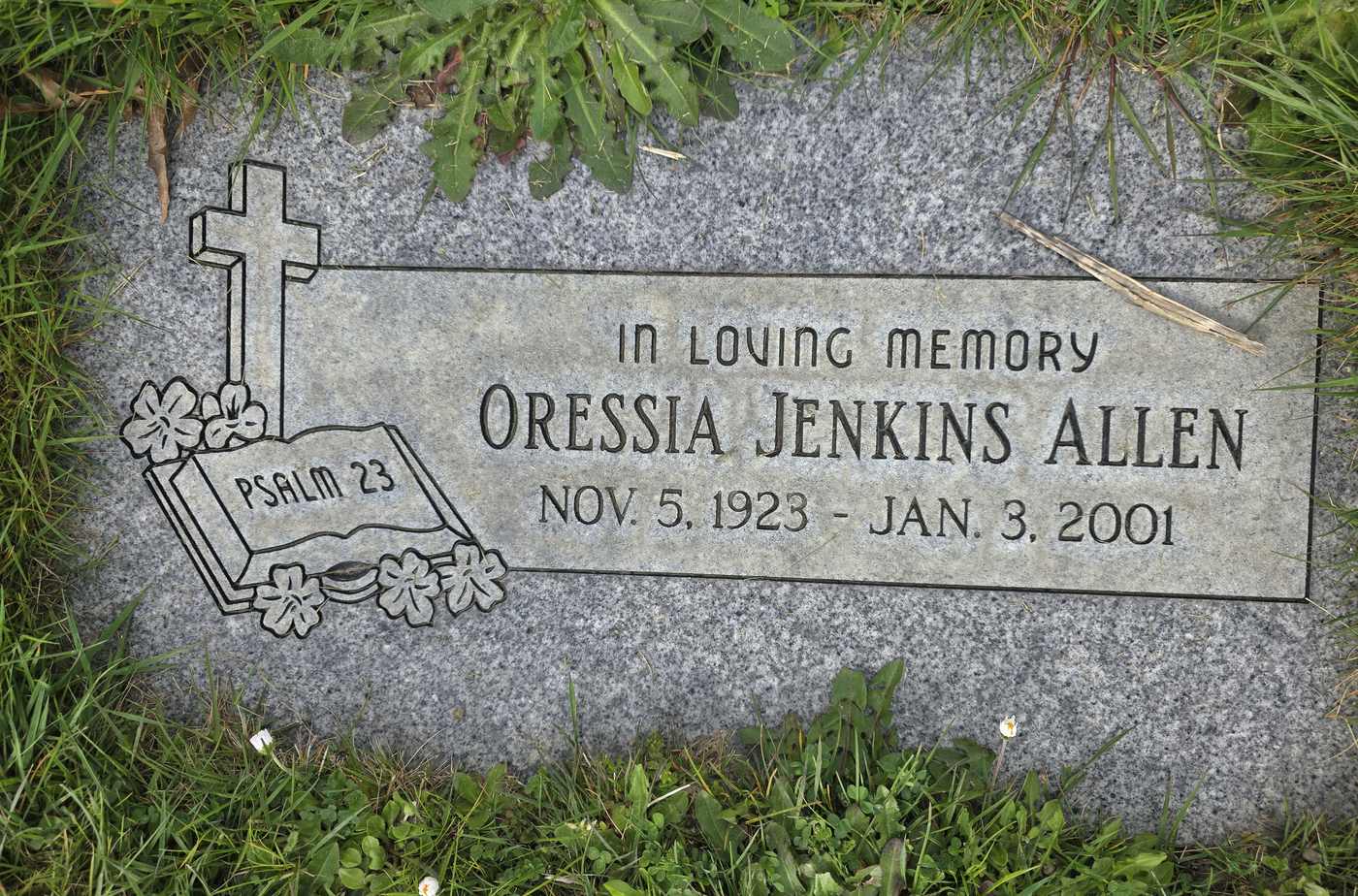 Grey granite with a raised cross and scripture