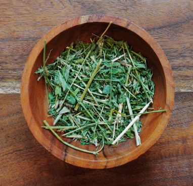 A wooden bowl of alfalfa