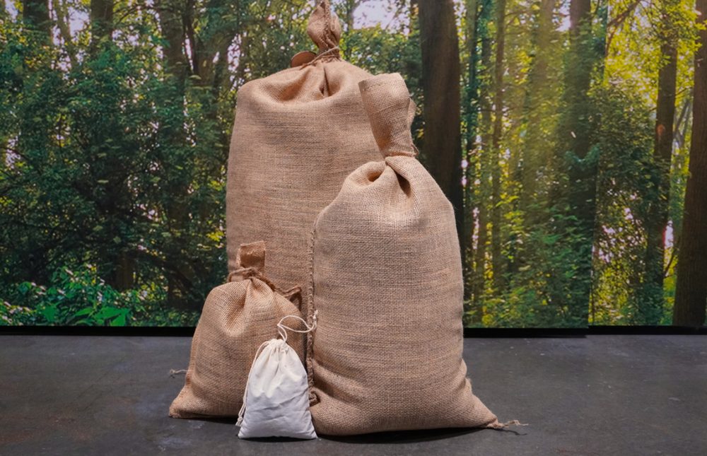 Four burlap bags of terramated soil in graduated sizes, from a large sack down to a small drawstring pouch