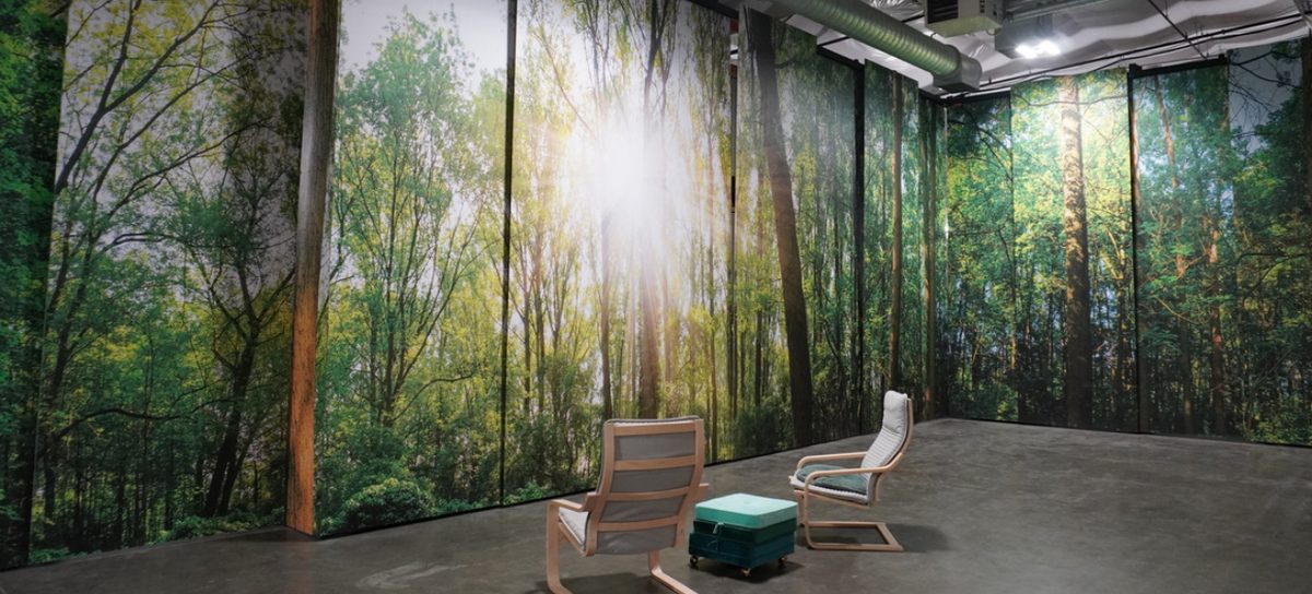 A quiet room at the Return Home facility with two chairs, walled floor to ceiling with a forest photograph