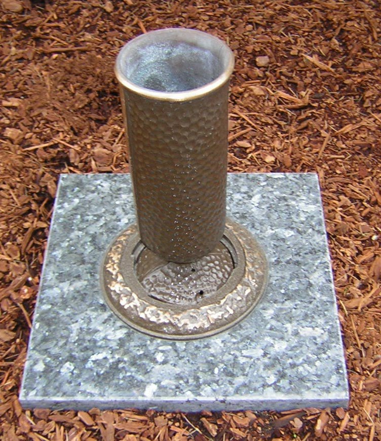 Hammered bronze Doric vase with a hammered ring set in a granite block